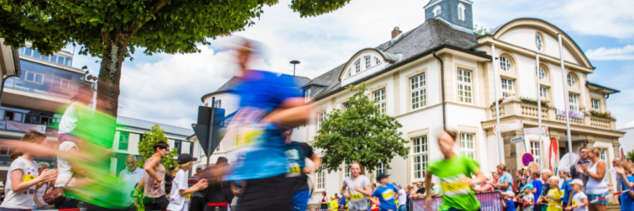 Läuferinnen und Läufer im Zieleinlauf vor dem historischen Rathaus in Hennef