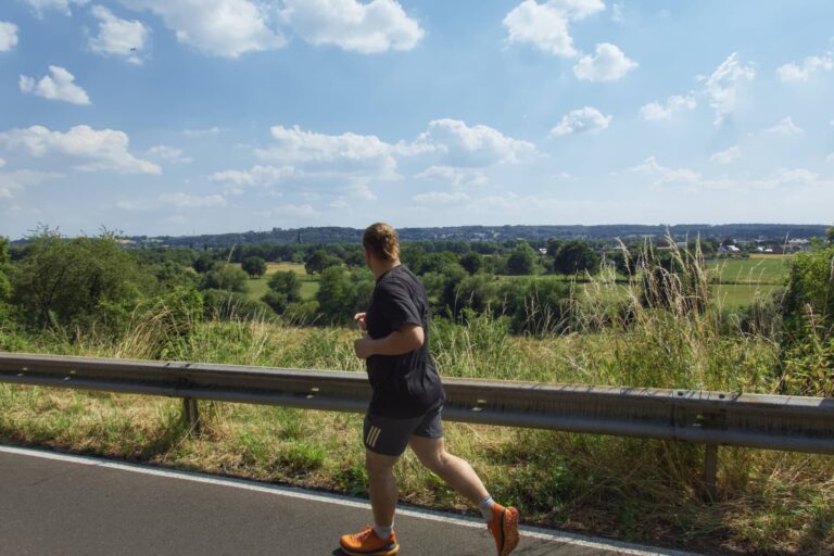 Läufer nimmt am Europalauf Hennef teil und joggt eine Straße mit Ausblick entlang.
